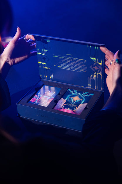 Person opening a dark blue gift box with colorful items inside against a dark background
