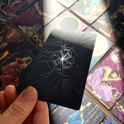 Card with spider web design held over a collection of tarot cards. Dark reflections tarot by La Muci Available at Oneness Emporium