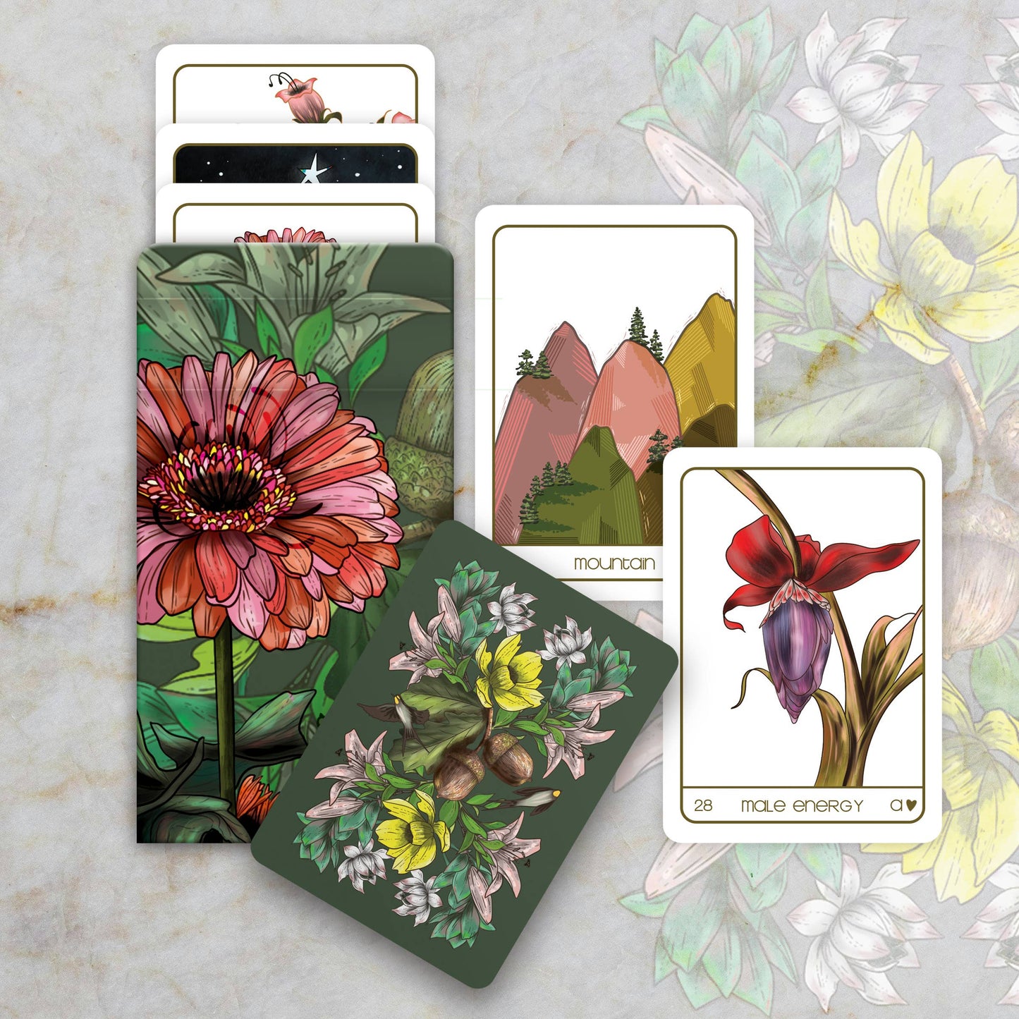 Set of tarot cards with nature-themed designs on a marble surface.