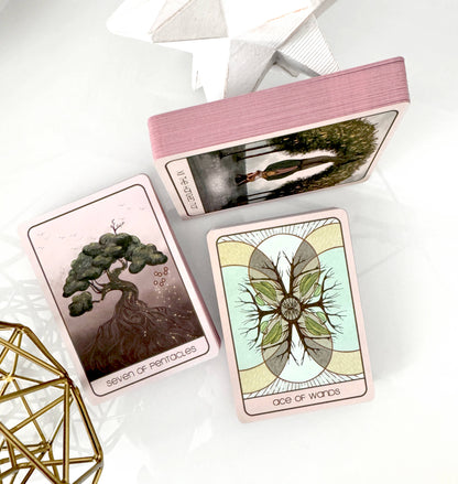 Two tarot cards with nature-themed designs on a white surface.