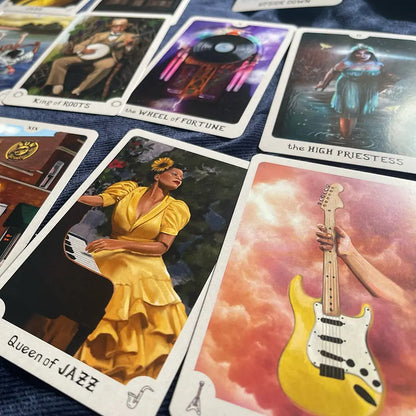 Collection of tarot cards with various illustrations including a woman in a yellow dress, a guitar, and a person on a horse.