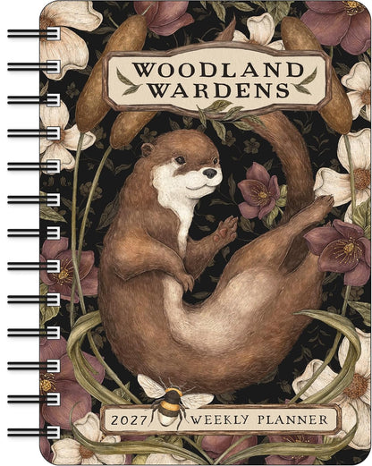 Woodland Wardens 2027 Weekly Planner with a spiral binding, featuring an illustration of an otter surrounded by flowers and leaves on a dark background.