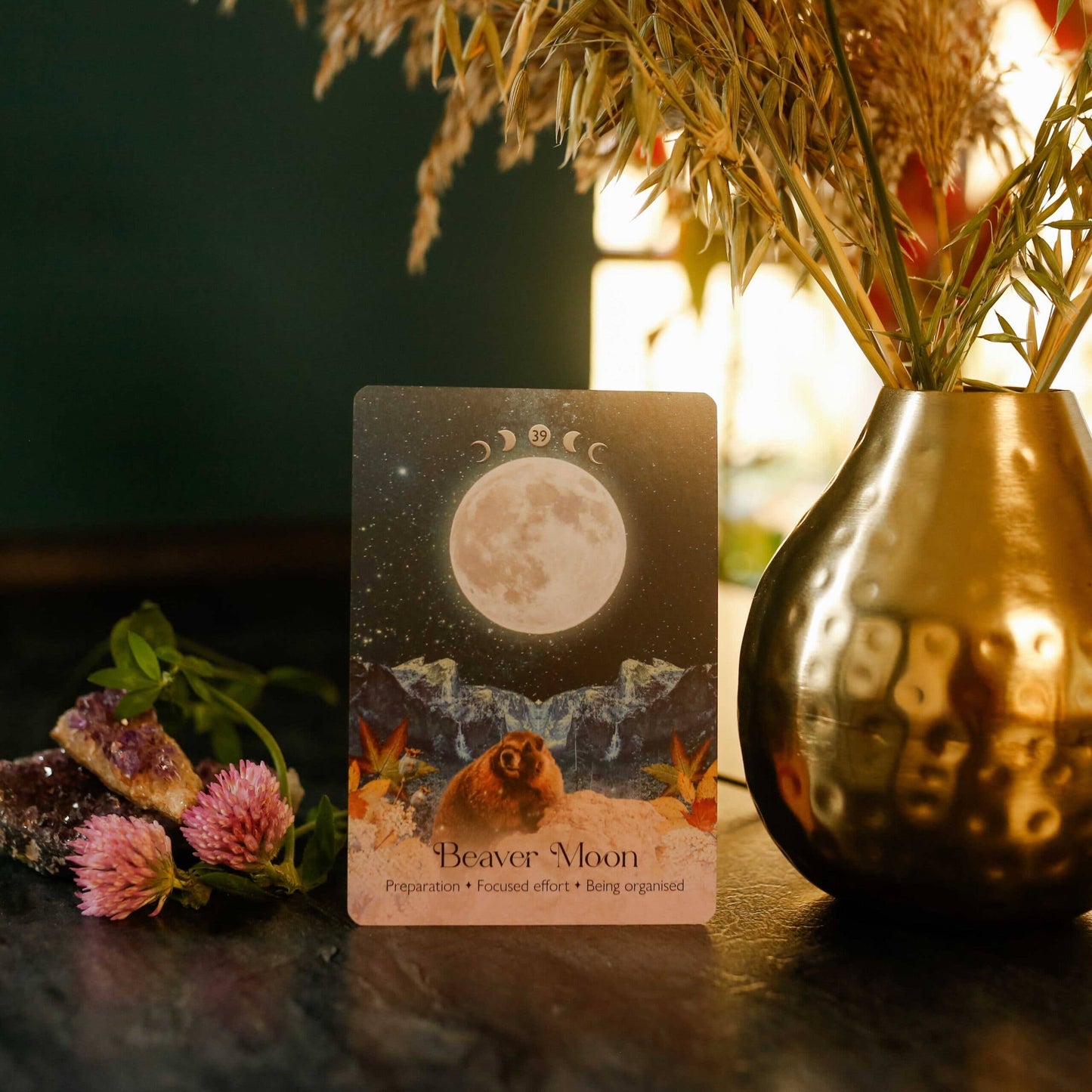 Card with 'Beaver Moon' design on a dark surface with decorative elements