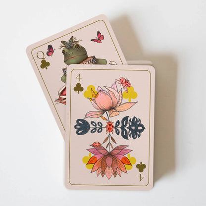 Two playing cards with floral and nature-themed designs on a white background