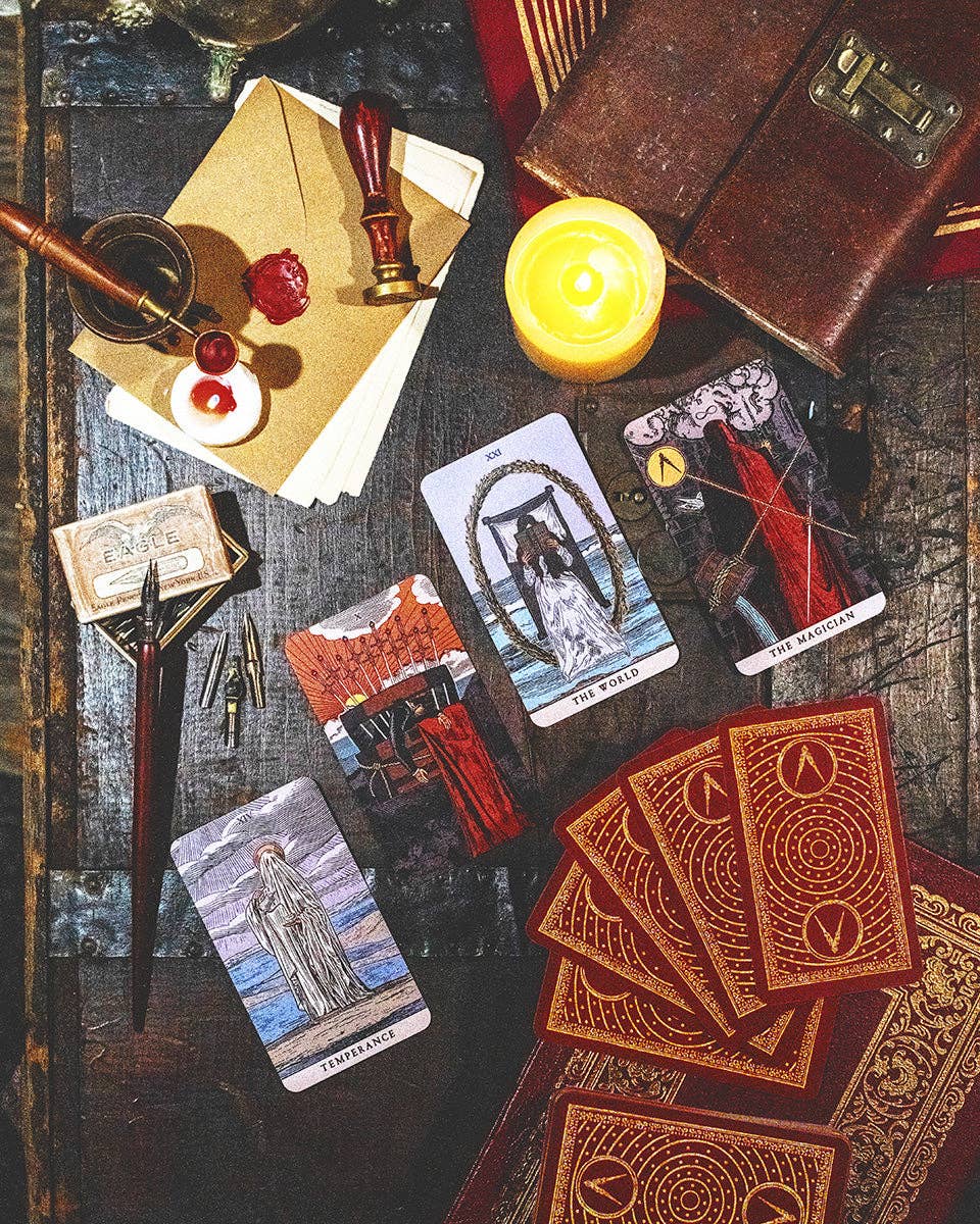 Tarot cards and mystical items on a wooden surface with a candle.