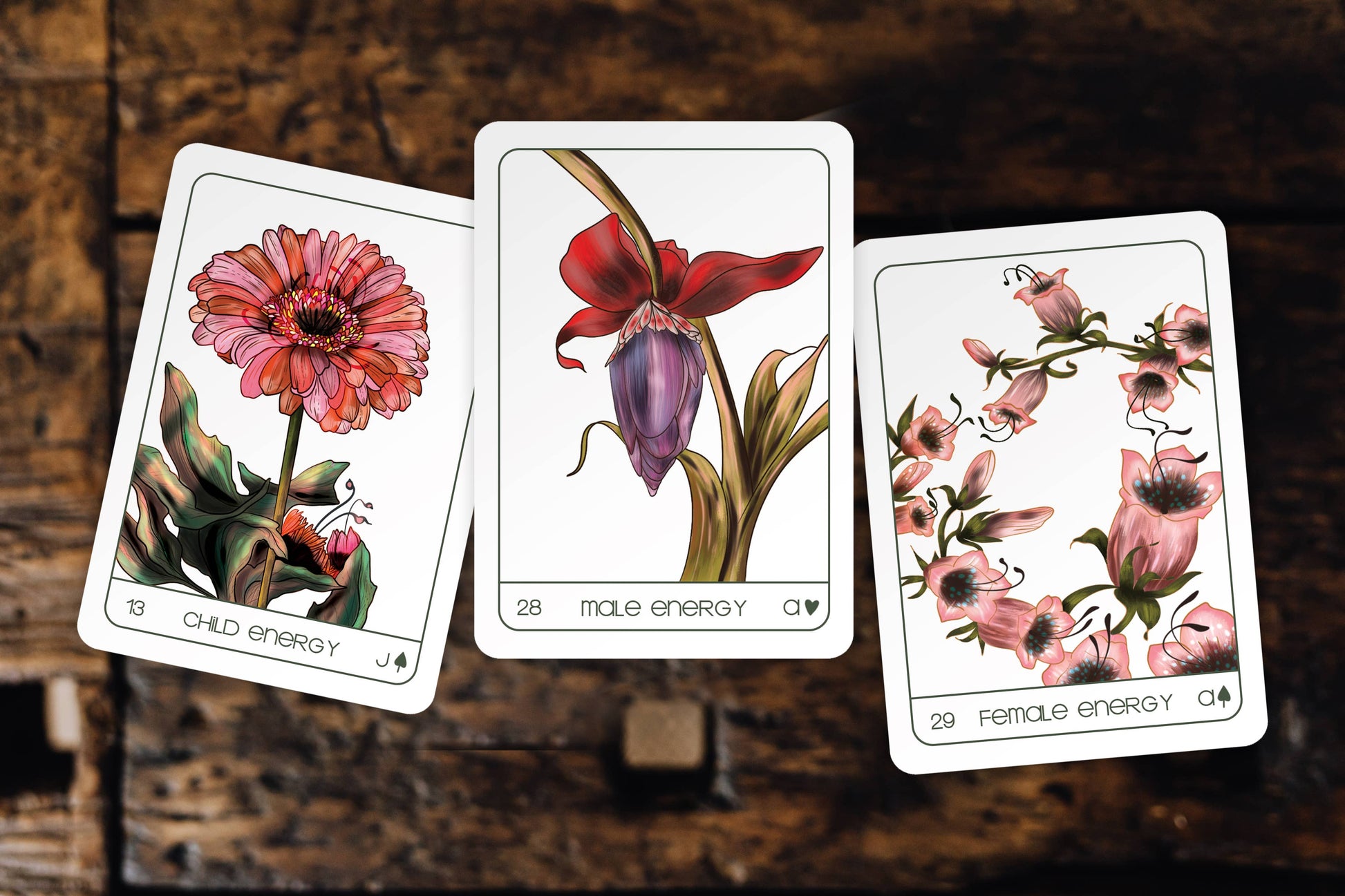 Three tarot cards with floral designs on a wooden surface