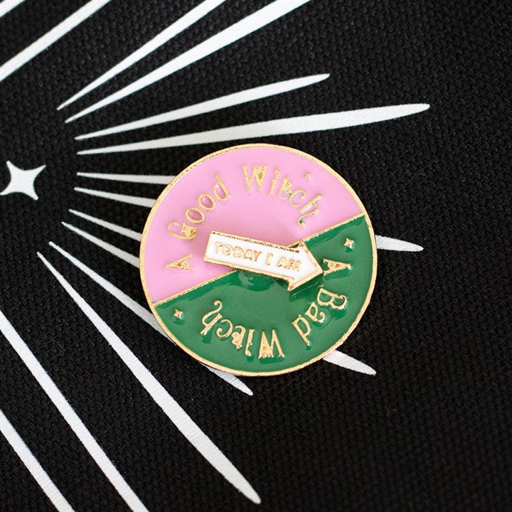 Which Witch Are You spinning enamel pin badge with pink, green and white design and interactive rotating arrow.
