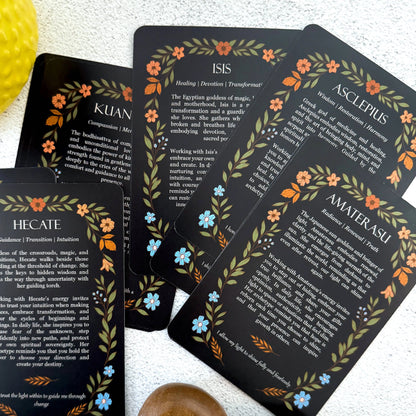 Set of tarot cards with goddess names and descriptions on a white surface.