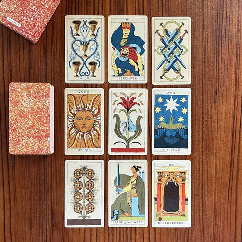 Set of tarot cards on a wooden surface Othrysian tarot Michael Ezzell Oneness Emporium