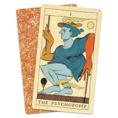 Tarot card titled 'The Psychopomp' with a stylized figure on a white background Set of tarot cards on a wooden surface Othrysian tarot Michael Ezzell Oneness Emporium