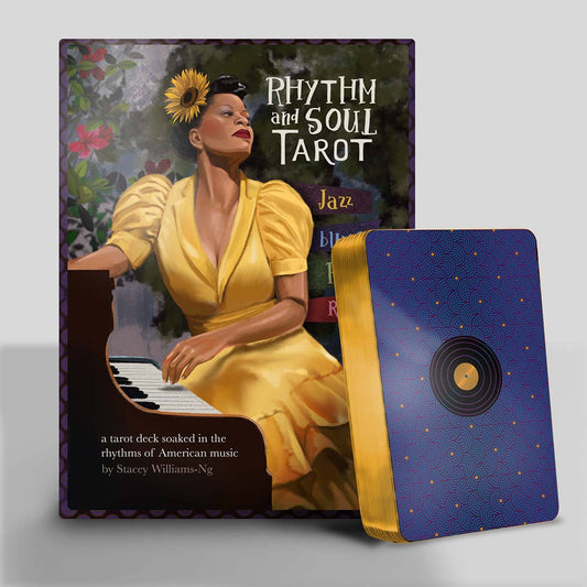 Rhythm and Soul Tarot  with a woman in a yellow dress sitting at a piano on the cover, next to a blue tarot card box.