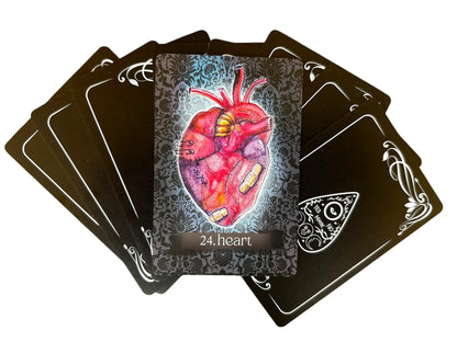 Playing card with a detailed illustration of a heart on a black card with ornate edges.