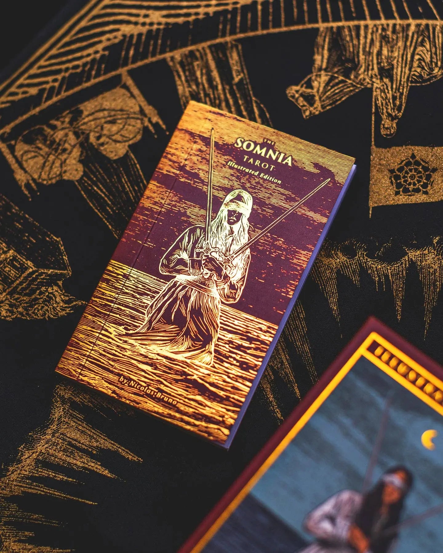 Two tarot card decks with intricate designs on a dark background
