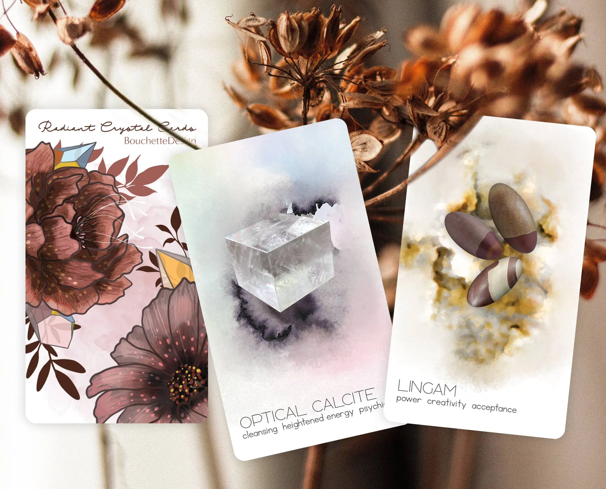 Three tarot cards with floral, crystal, and pebble designs on a blurred natural background. radiant crystal oracle
