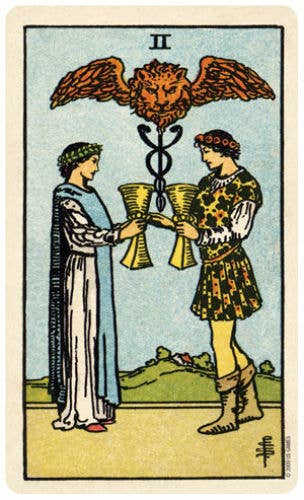 Tarot card with two figures holding cups and a lion symbol above them