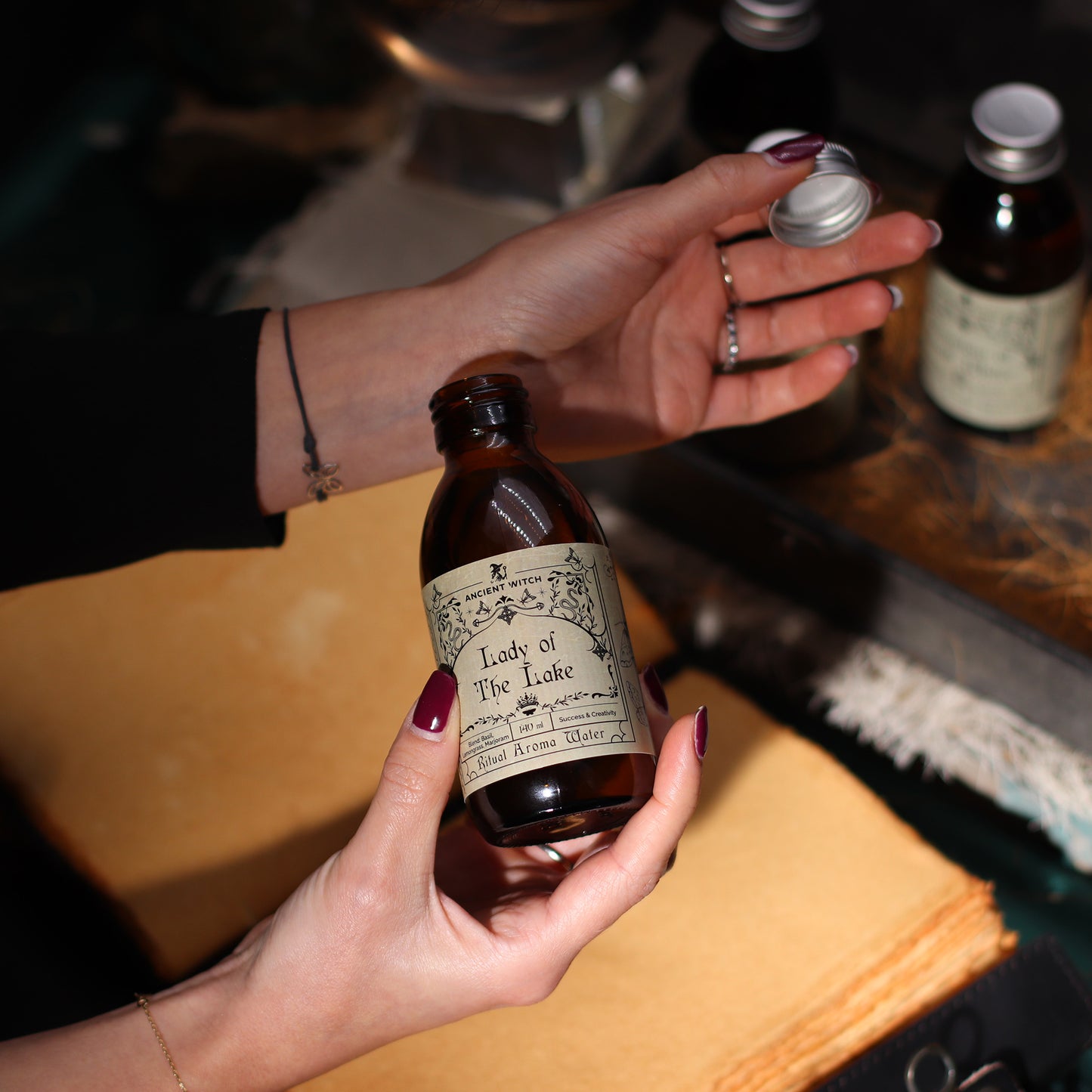 Person holding a bottle labeled 'Lady of the Lake' with a blurred background