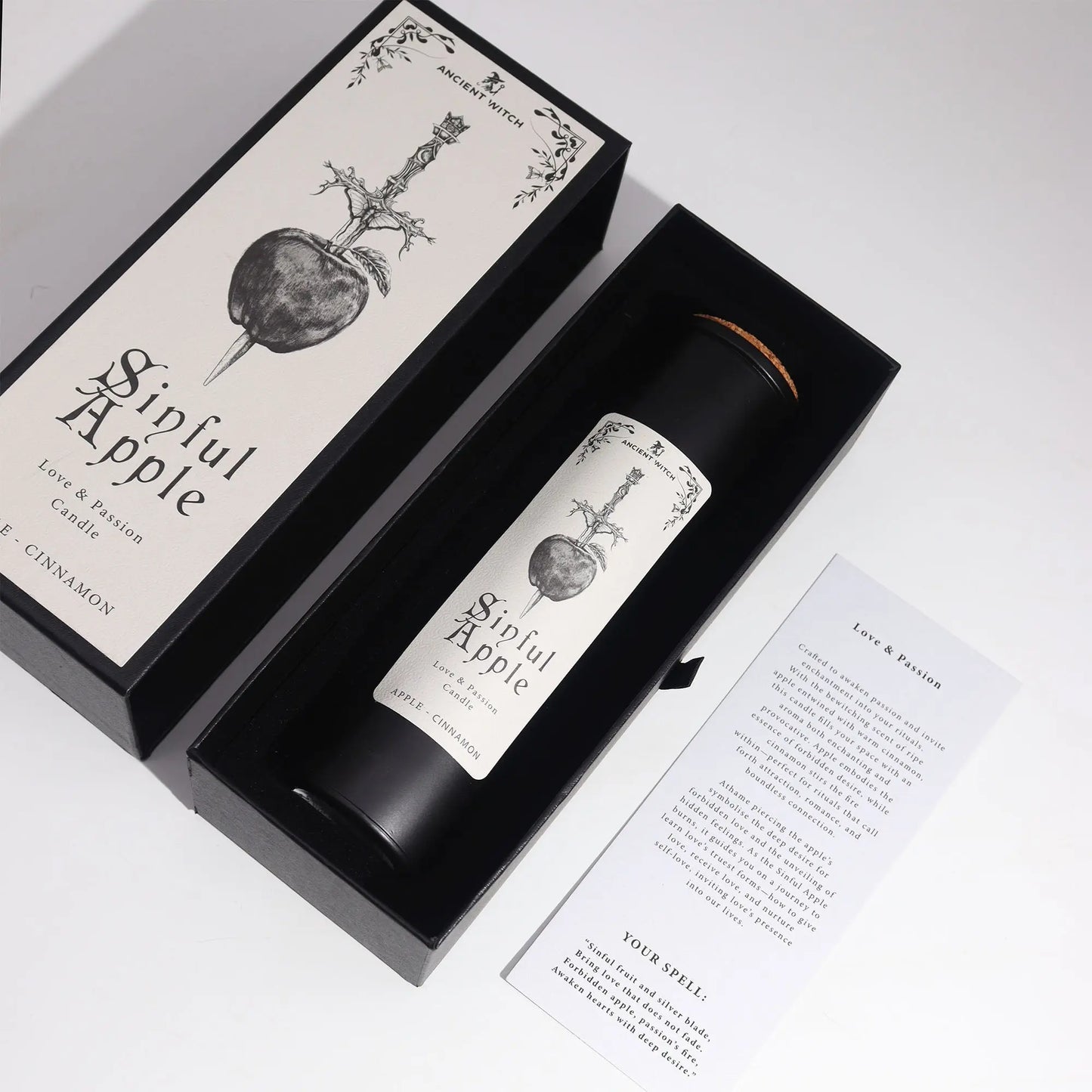 Candle labeled 'Sinful Apple' in a black box with decorative design on a white background