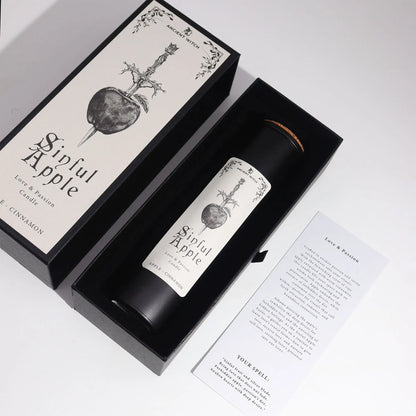 Candle labeled 'Sinful Apple' in a black box with decorative design on a white background