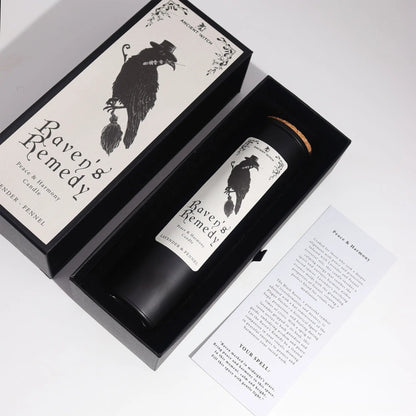 Candle labeled 'Raven's Remedy' in a decorative box on a white background