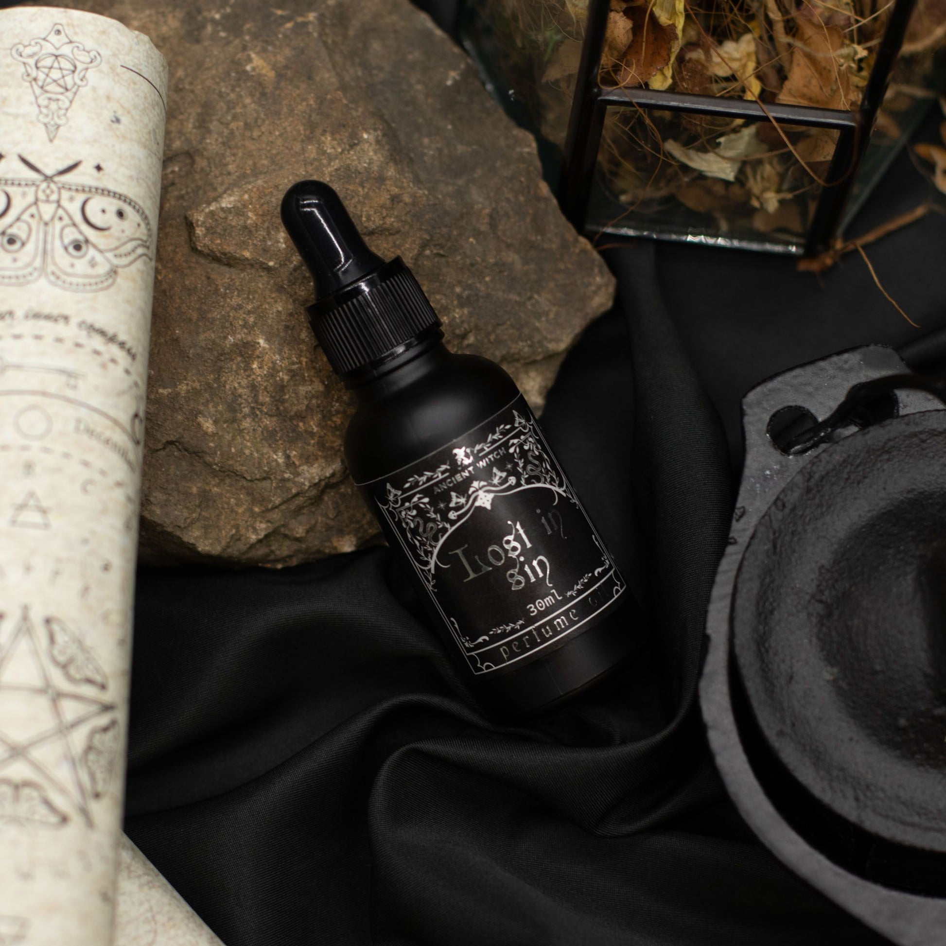 Black bottle with dropper labeled 'Rashin' on a dark fabric background with mystical elements.