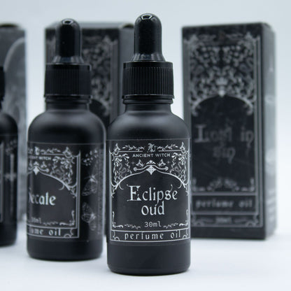 Black perfume oil bottles with labels on a white background