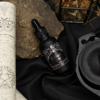 Black bottle with decorative label on a dark fabric background