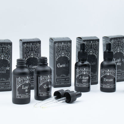 Perfume oil bottles and boxes with labels on a light gray background