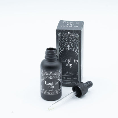Perfume oil bottle and packaging labeled 'Lost in Sin' on a white background