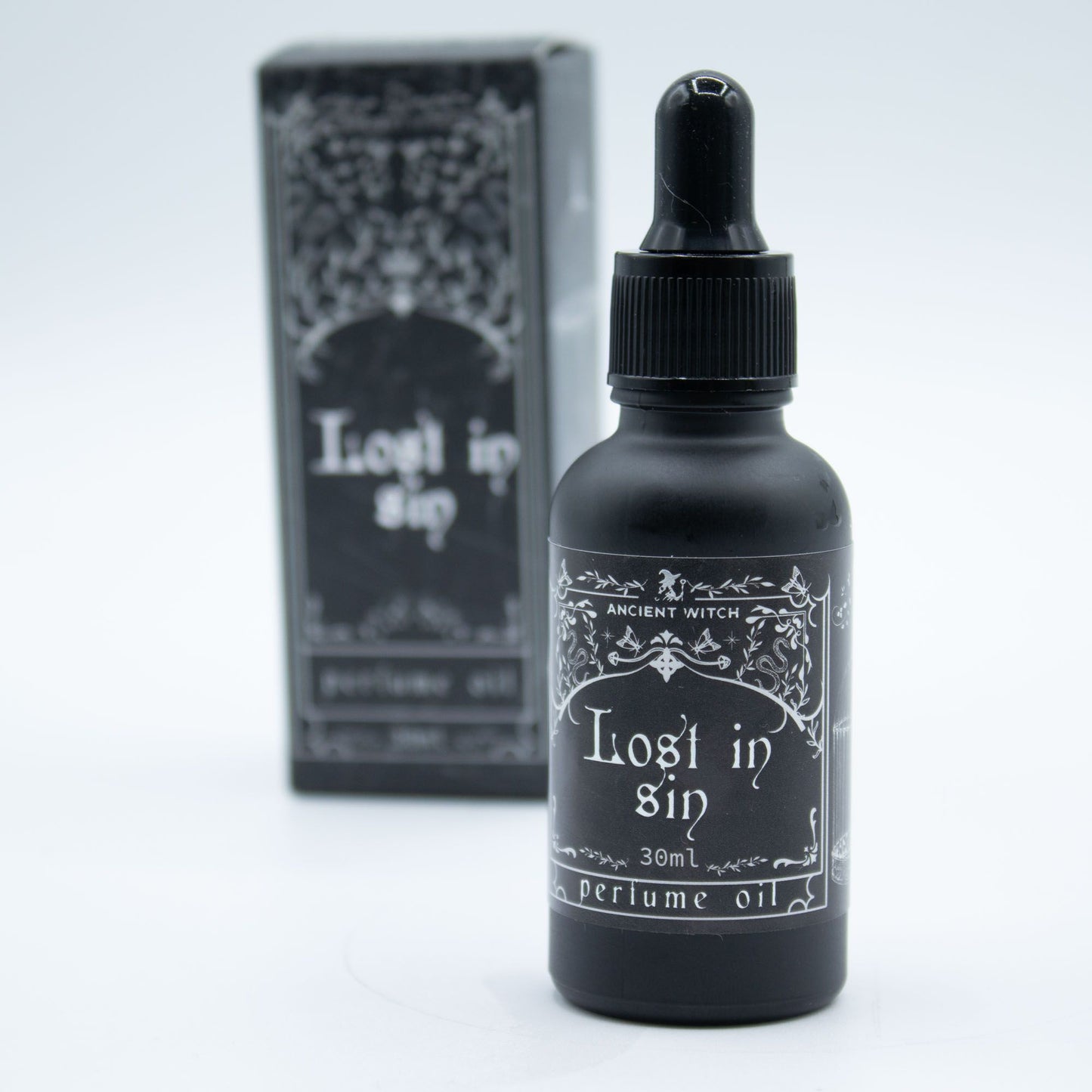 Black bottle of 'Lost in Sin' perfume oil with packaging on a white background