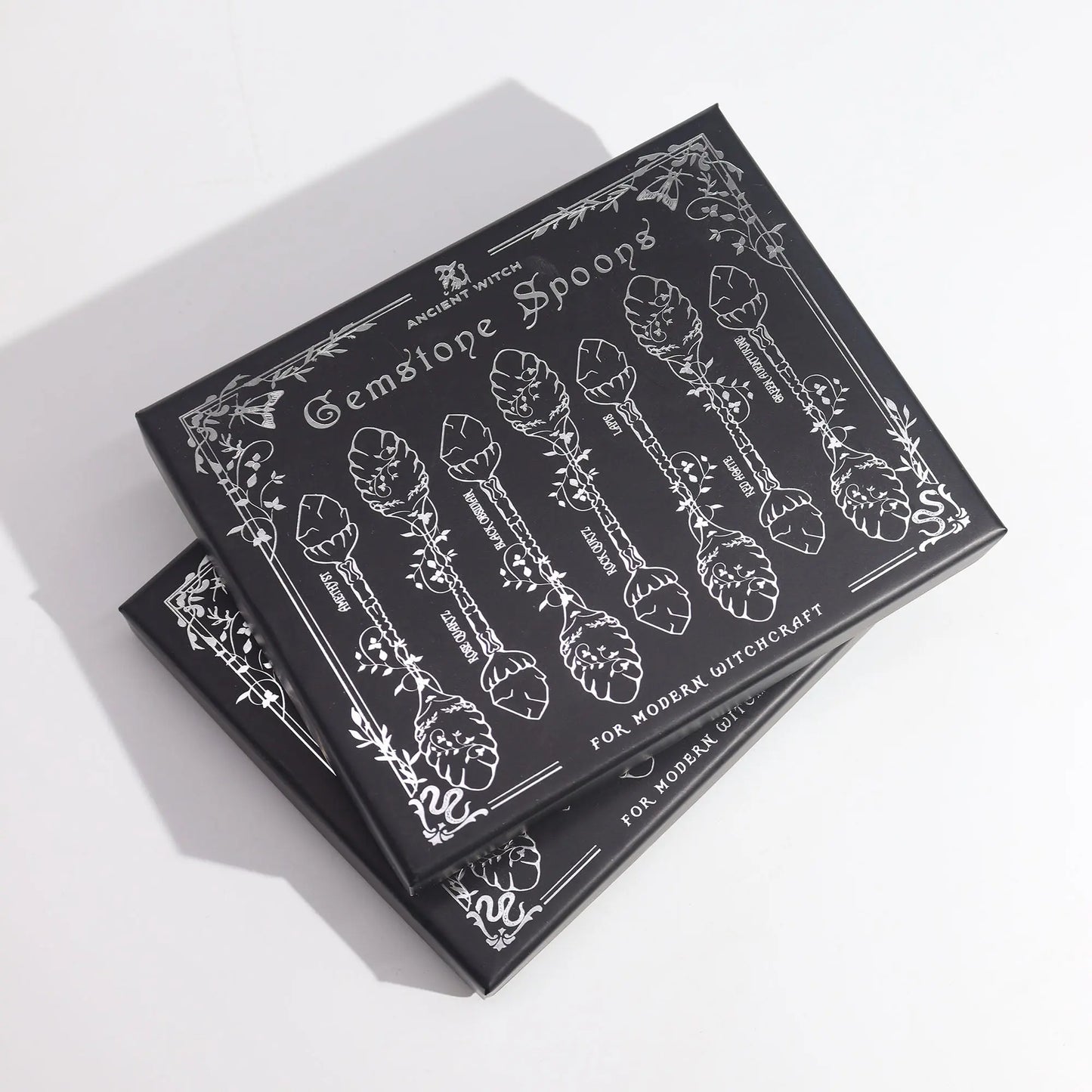Packaging for gemstone spoons with black and white design on a white background