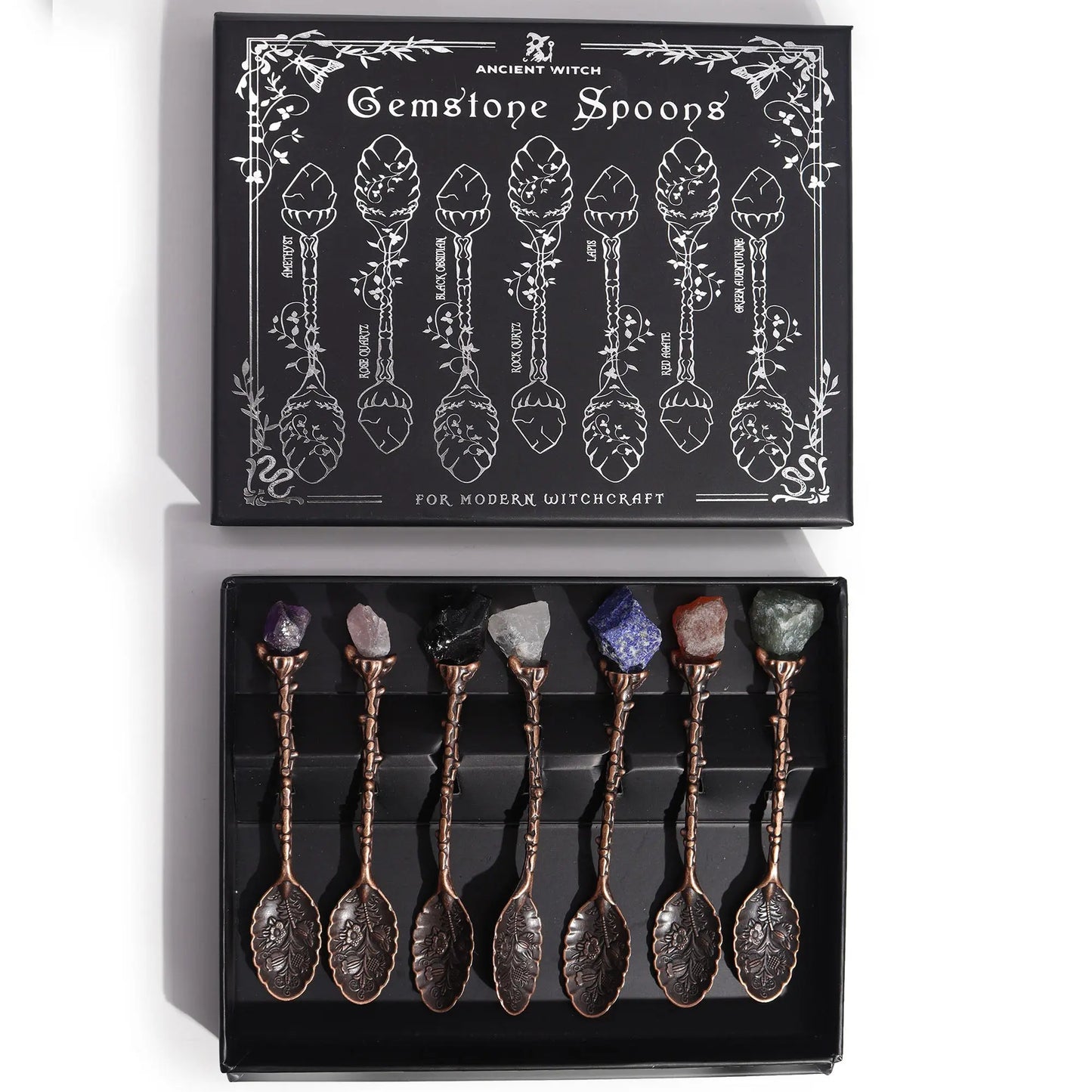 Set of gemstone spoons in a black box with decorative packaging.