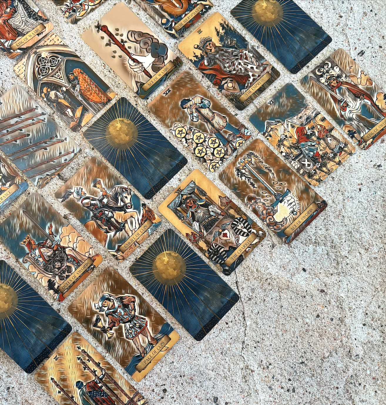 Collection of tarot cards arranged in a pattern on a textured surface