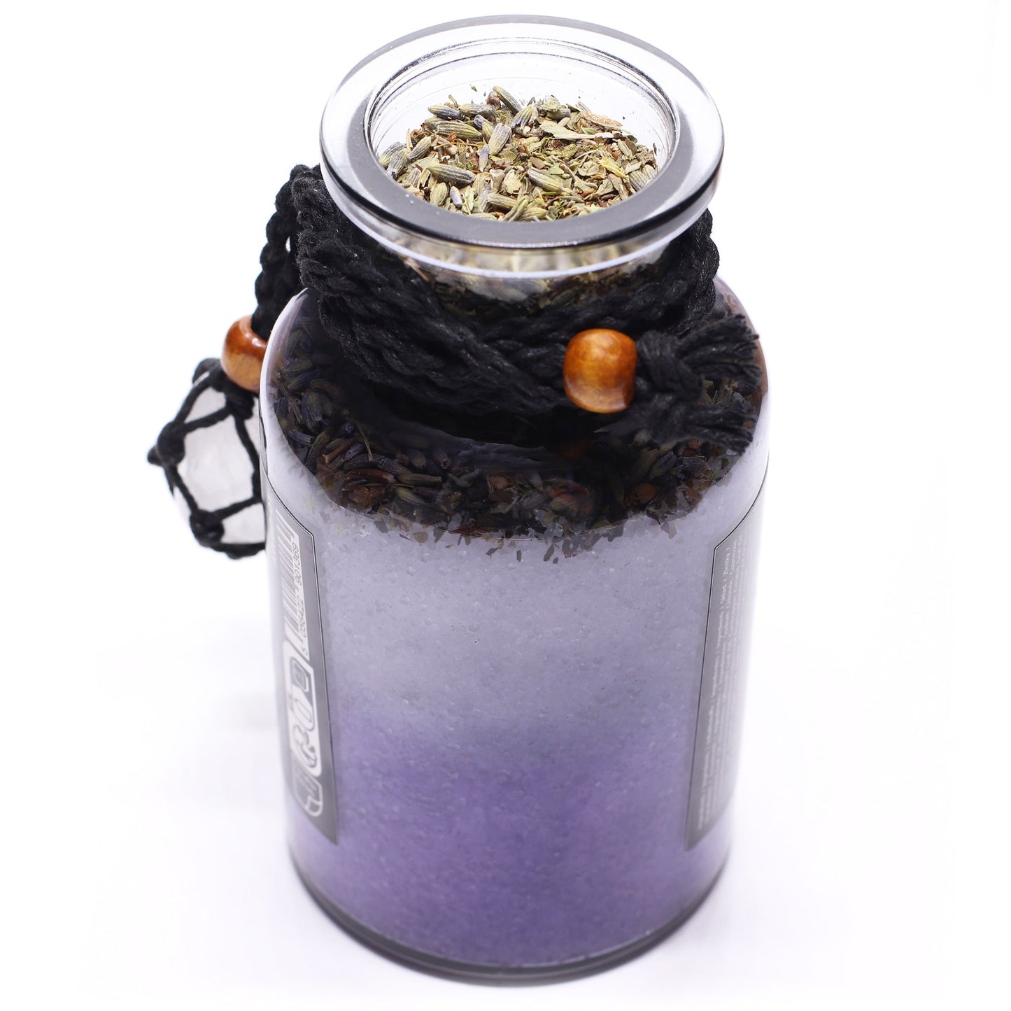 Glass jar with black rope lid containing dried herbs on a white background