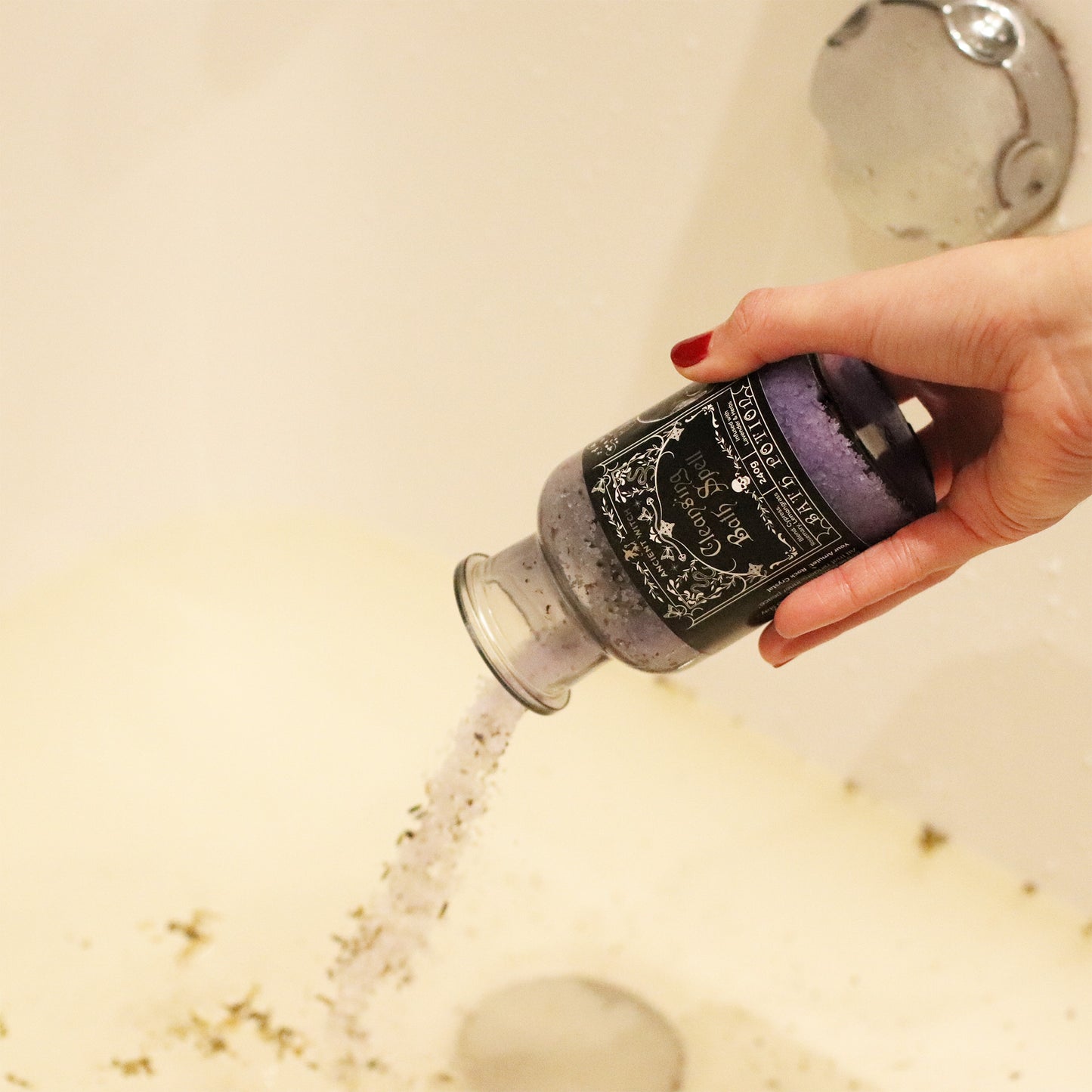 Hand holding a bottle of bath salt with a shower running in the background