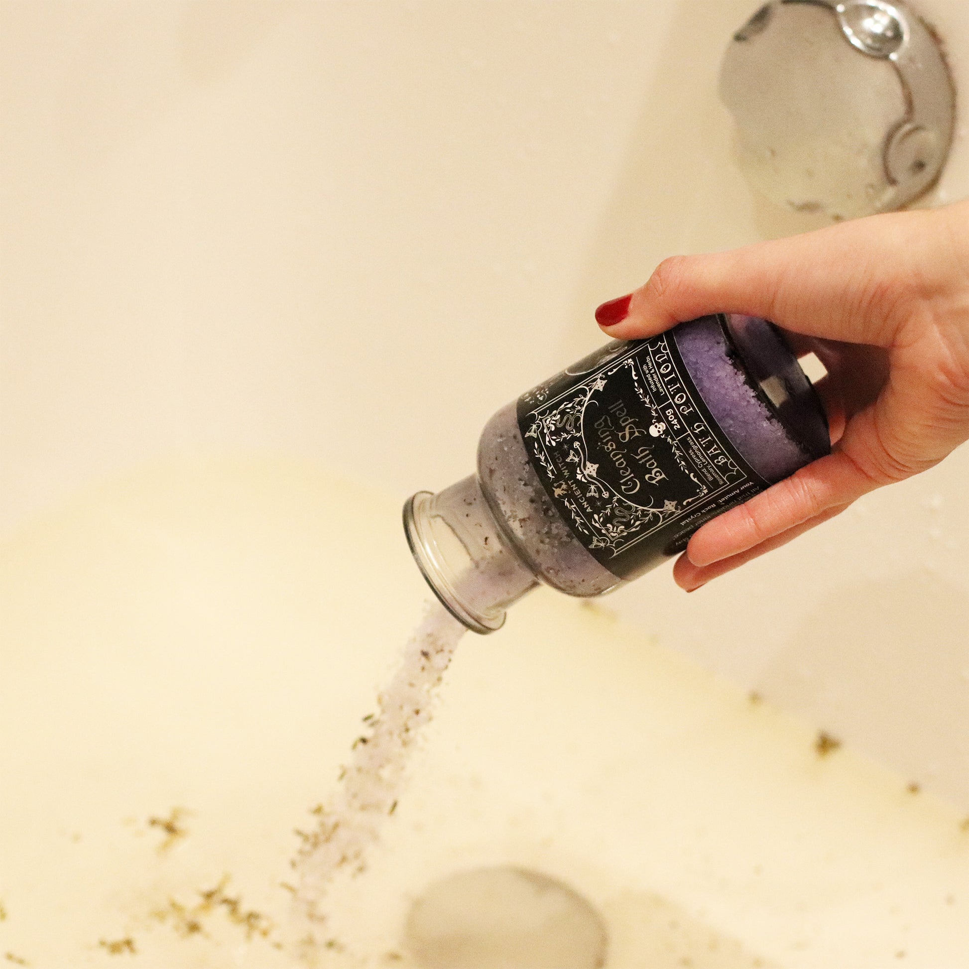 Hand holding a bottle of bath salt with a shower running in the background
