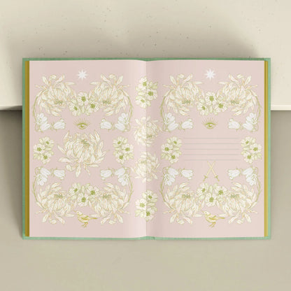 Open notebook with floral design on a light pink background Tarot Journal Bouchette and Co Oneness Emporium