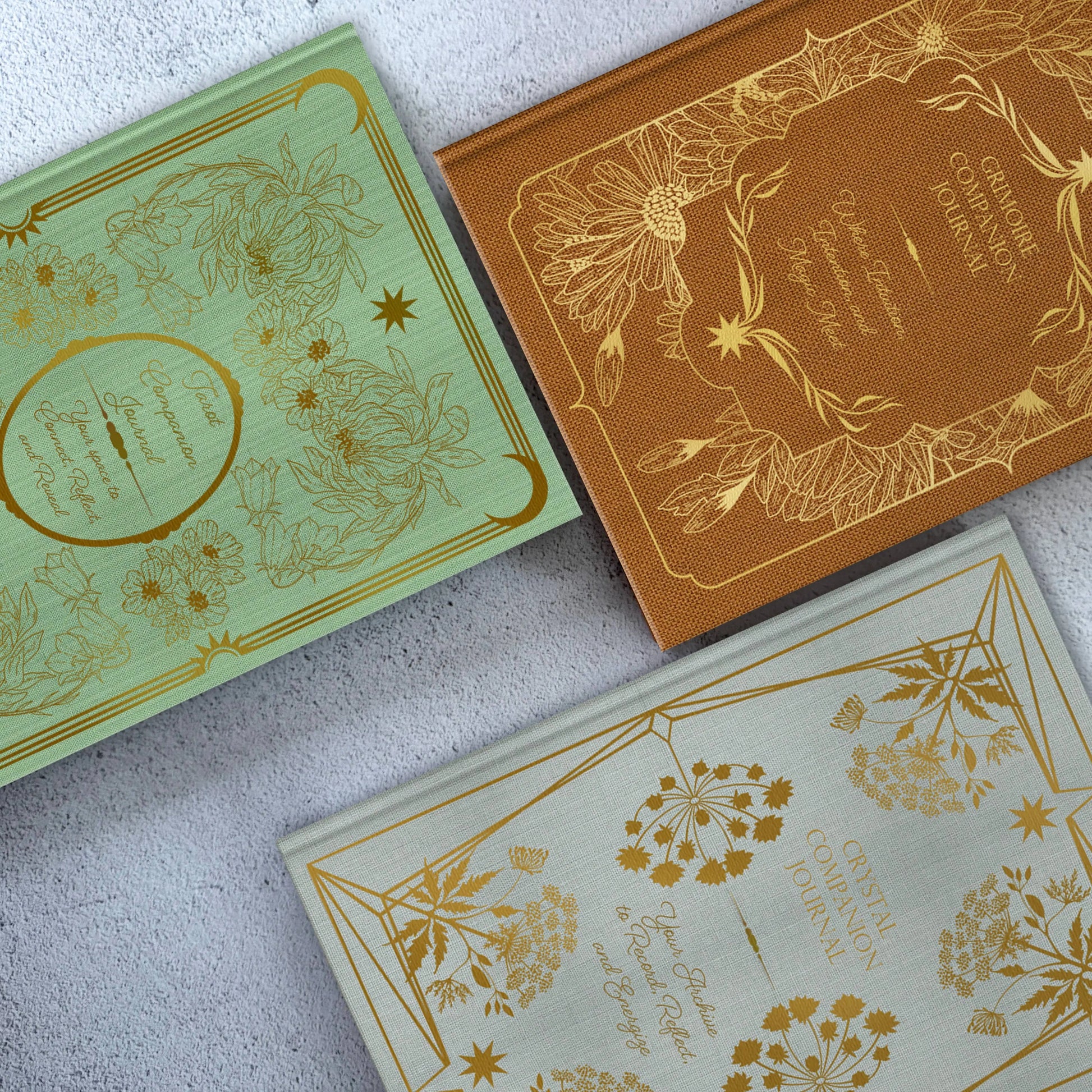 Three decorative boxes with gold embossed designs on a light gray surface Grimoire Bouchette and Co Oneness Emporium