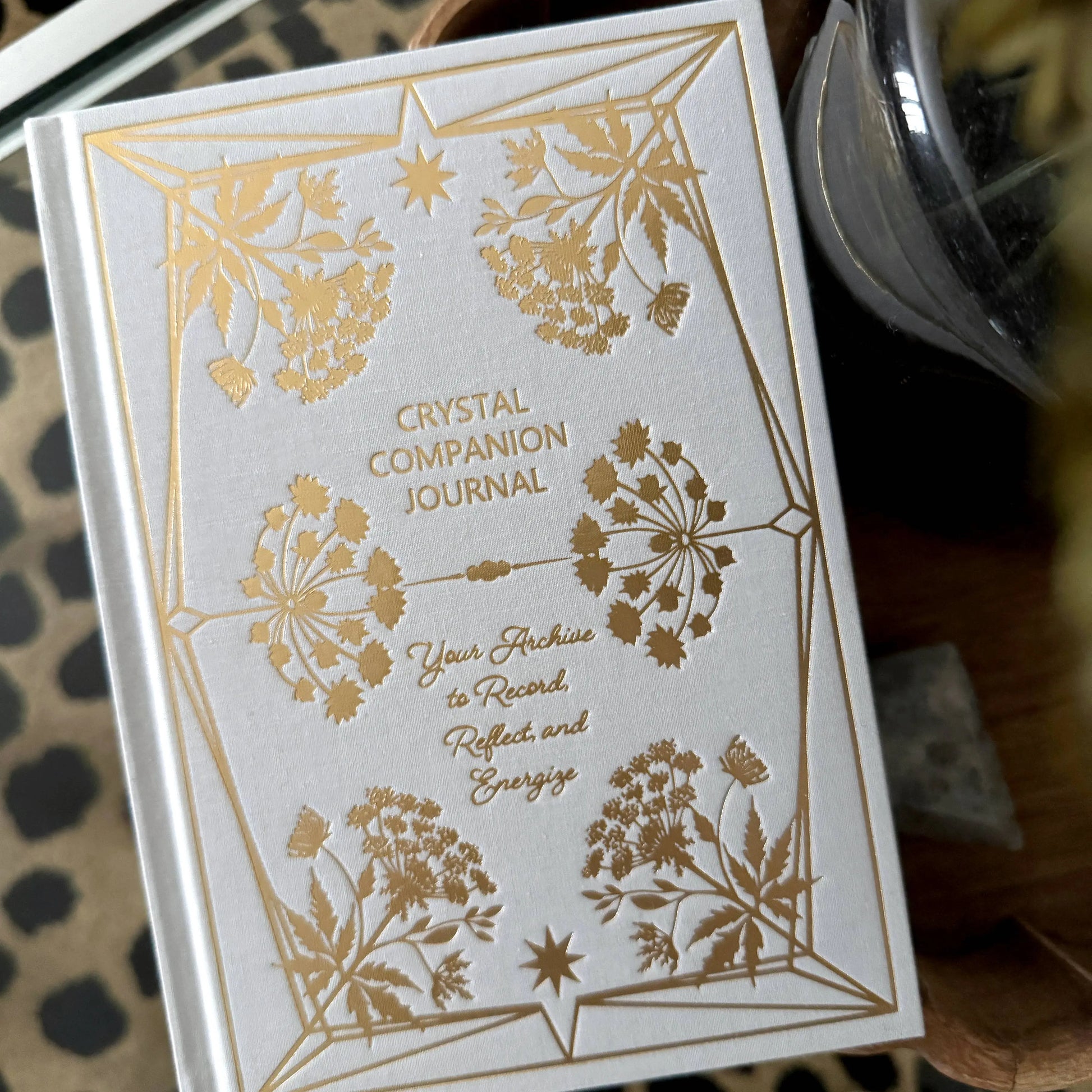 Crystal Companion Journal with gold floral designs on a white background Crystal companion journal by Bouchette and Co available from Oneness Emporium