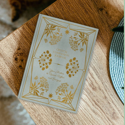 Decorative journal with floral designs on a wooden surface Crystal companion journal by Bouchette and Co available from Oneness Emporium