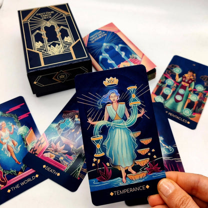 Collection of tarot cards with a focus on 'Temperance' card held by a hand, against a white background.