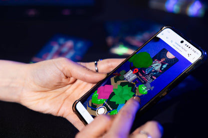 Person holding a smartphone with a colorful app interface on a dark background