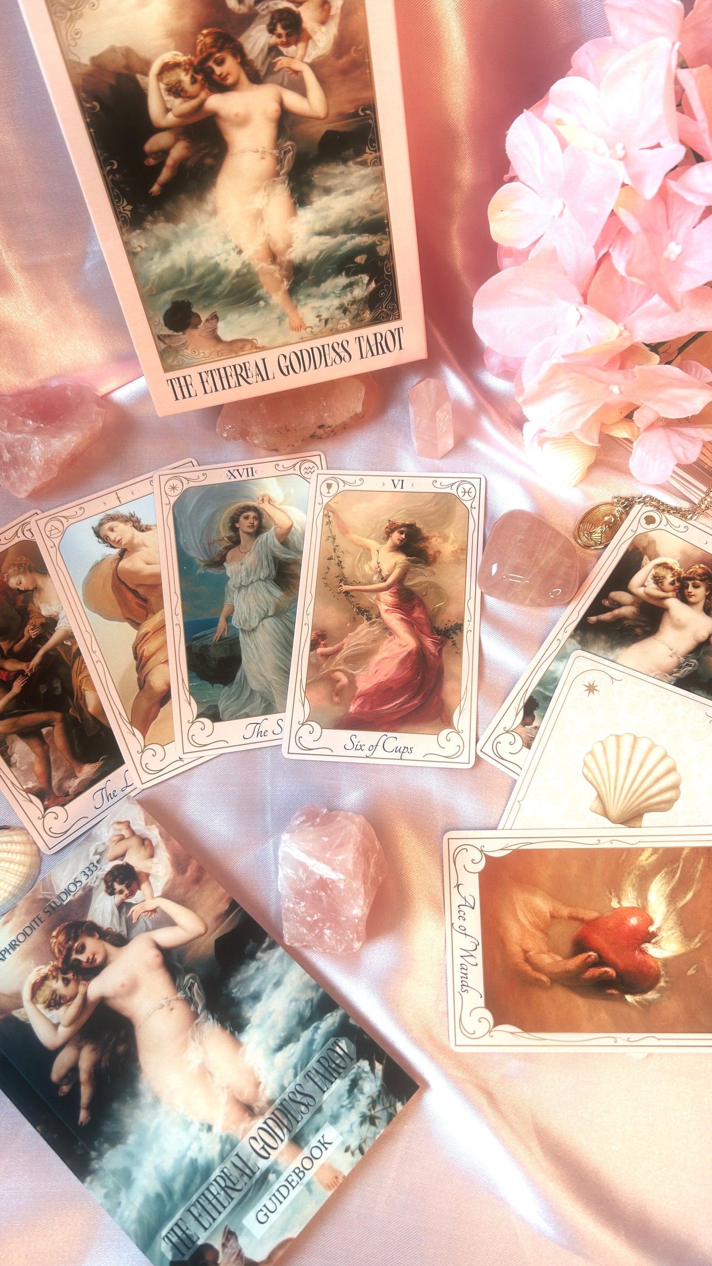 Collection of tarot cards with artistic illustrations on a soft pink background.