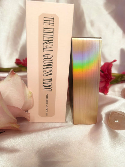 Ethereal Goddess tarot deck showing the spne of the box and rainbow gold gilding on the edges of the cards. Surrounded by silk and rose petals. Available from Oneness Emporium