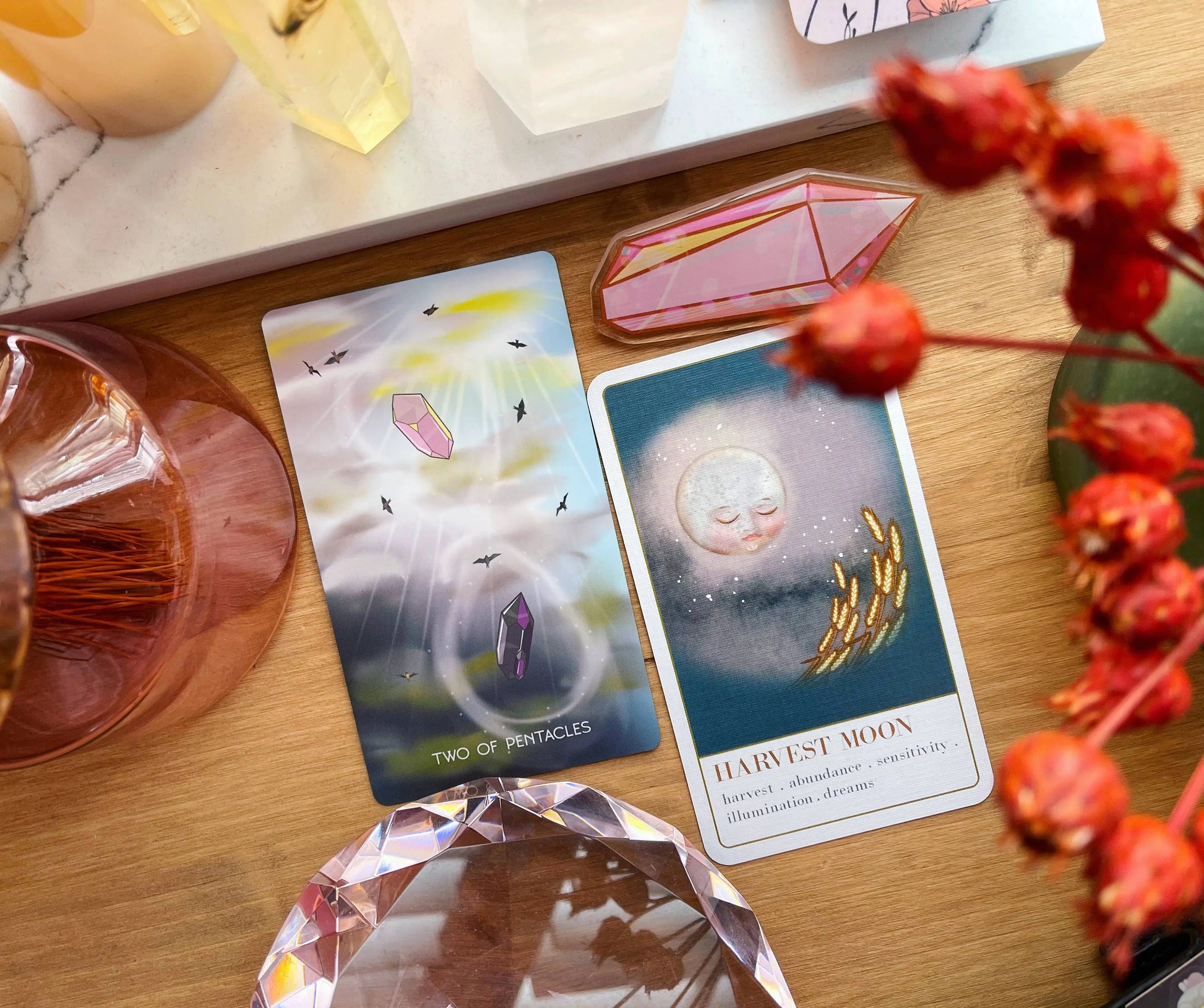 Wanderlust collection oracle deck Two tarot cards on a wooden surface with decorative elements.