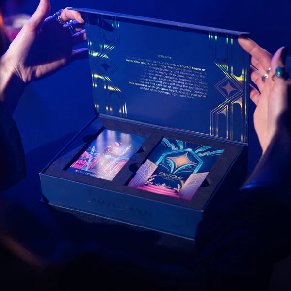 Open box with electronic devices and text, held by a person in a dark setting