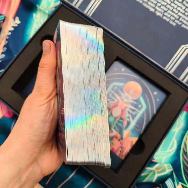 Hand holding a deck of cards with colorful designs in the background