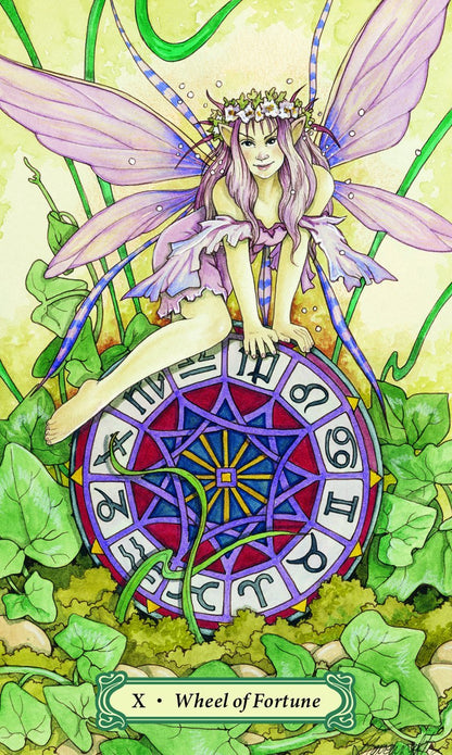 Mystic Faerie Tarot deck by Linda Ravenscroft featuring whimsical faerie themed tarot artwork. Fairy sitting on a Wheel of Fortune card with green leaves and flowers in the background