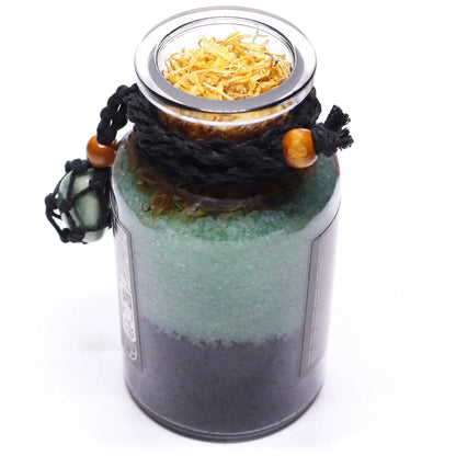 Decorative jar with layered sand and a lid on a white background