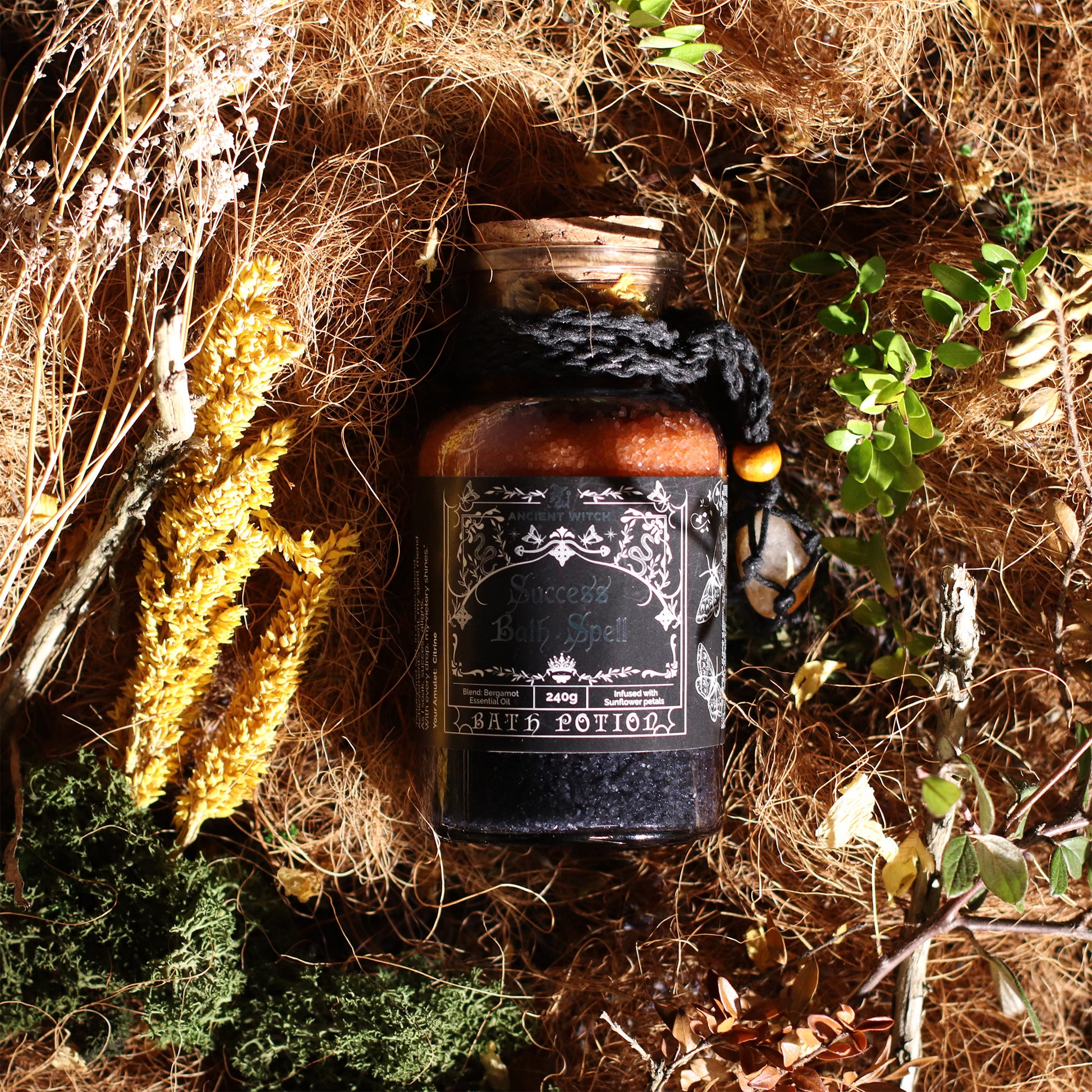Bottle labeled 'Sorceress' on a natural background with plants and hay.