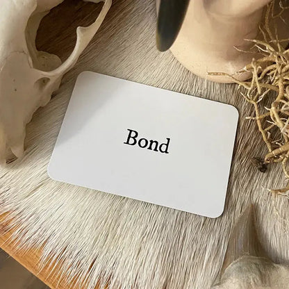 White card with 'Bond' text on a wooden surface with decorative elements